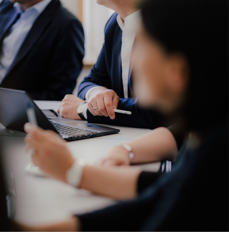 Anwälte und Mitarbeiter sitzen an Tisch in Anwaltskanzlei